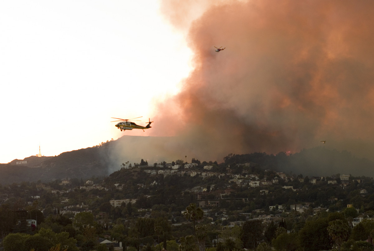 USA, California, Los Angeles, helicopters hovering over brush fire - Stock-Fotografie