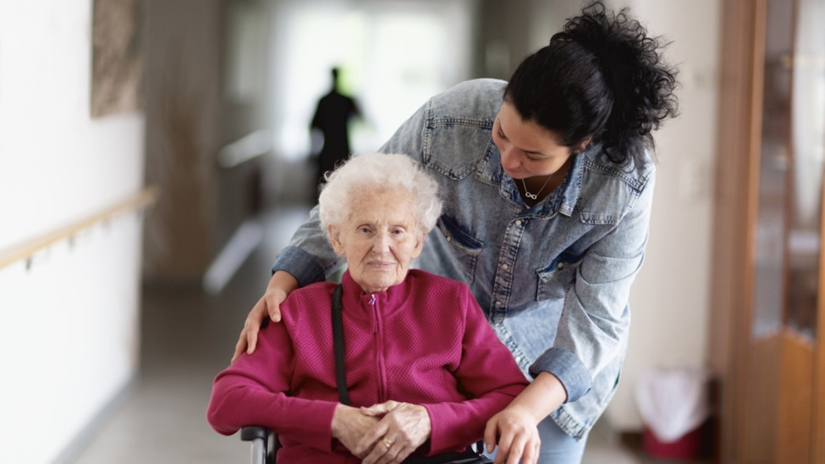 Alte Dame im Pflegeheim mit ihrer Betreuerin