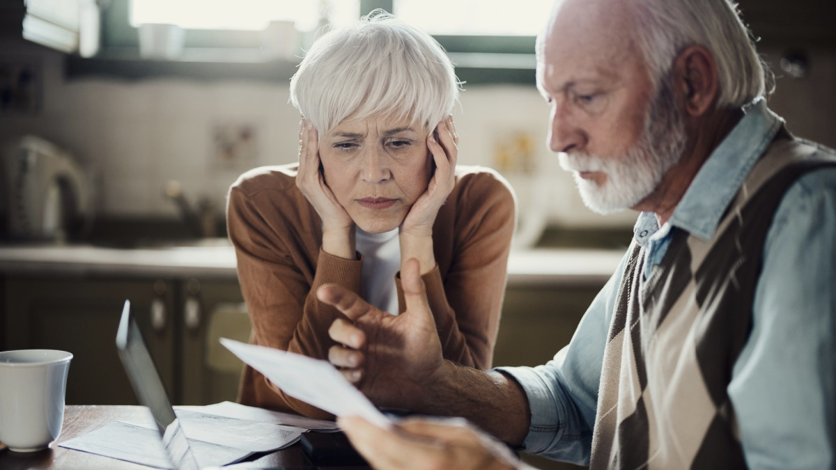 Ernstes, älteres Paar prüft Verträge