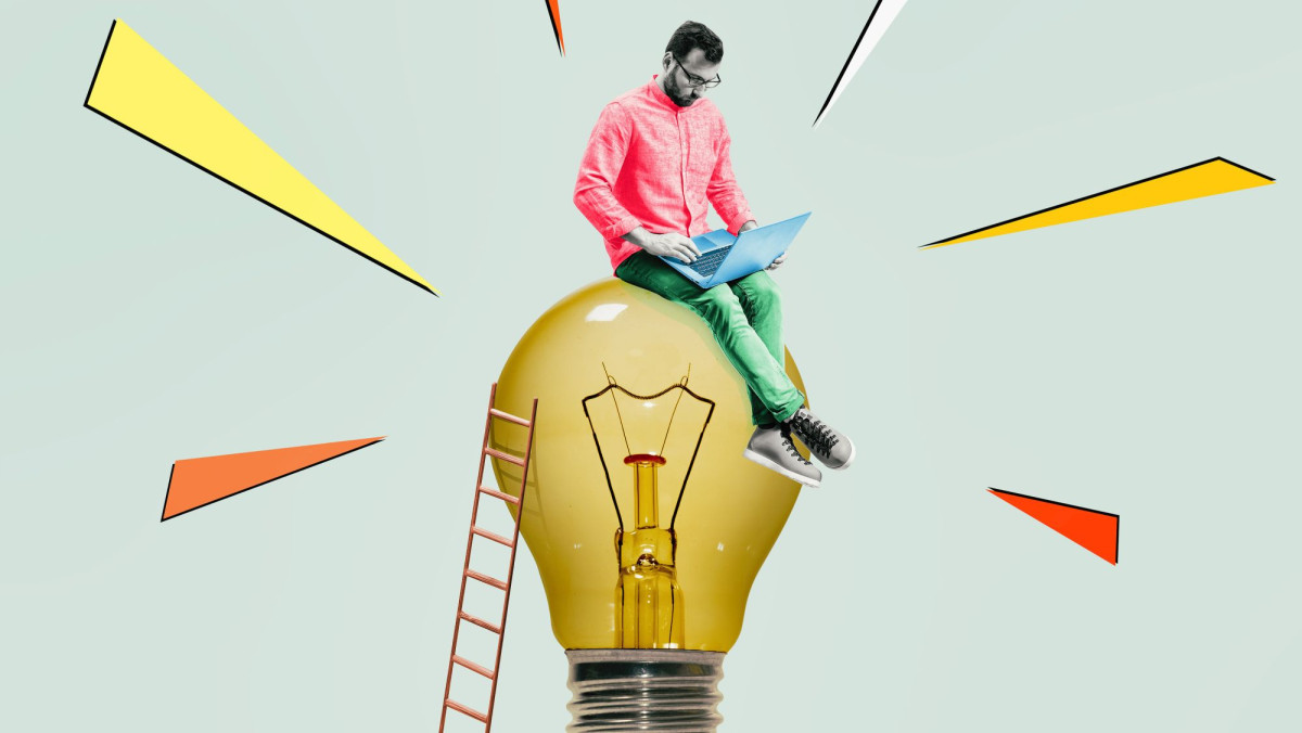 Mann mit Laptop auf Glühbirne