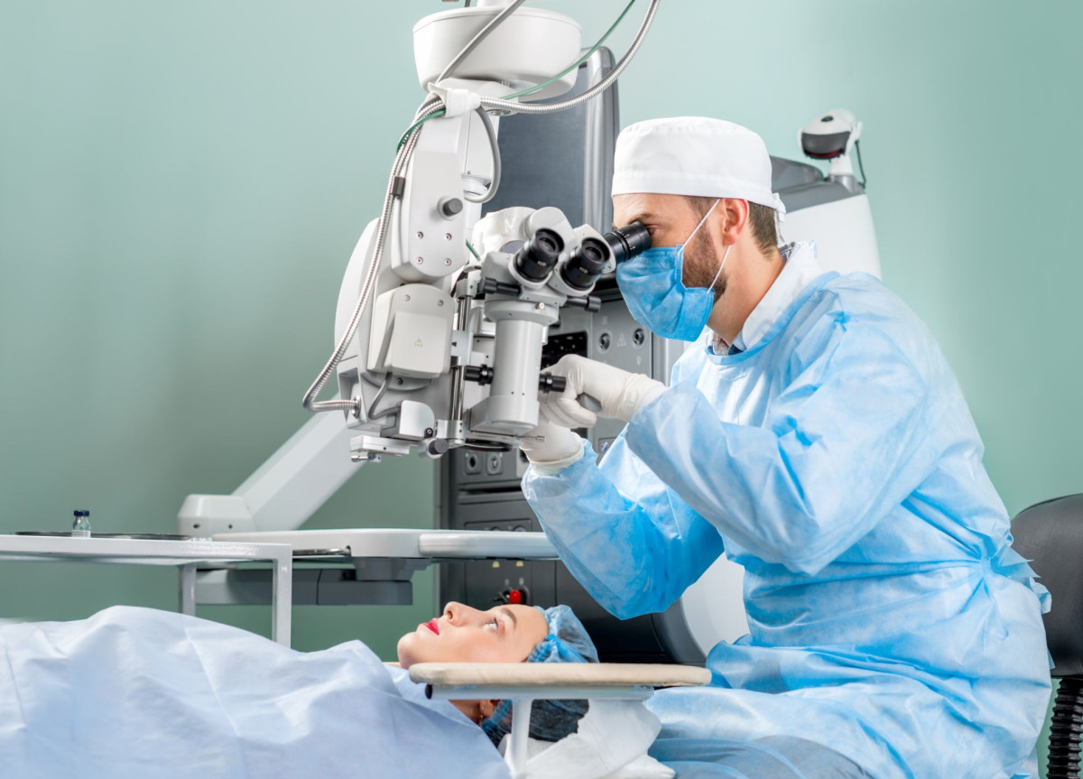 Ein Arzt betrachtet per medizinischem Gerät die Augen einer Patientin