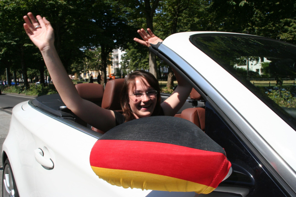 Eine Frau feiert in einem offenen Auto den Sieg der deutschen Fußballmannschaft