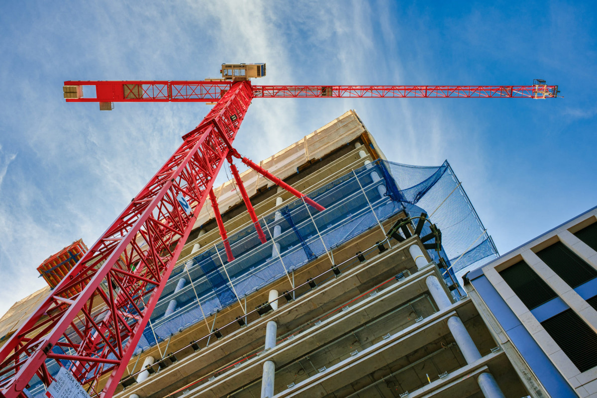 Roter Baukran vor einer Baustelle