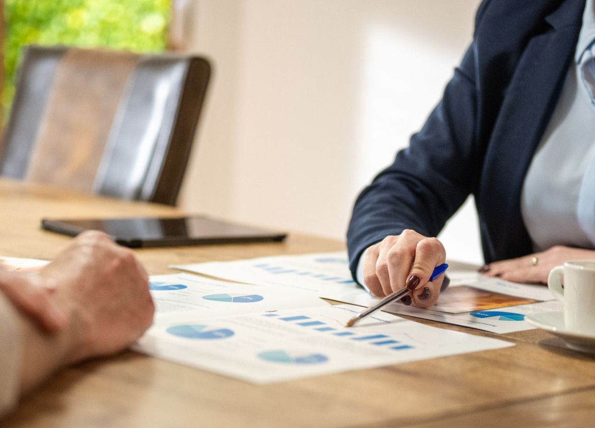 Eine Verkäuferin zeigt auf diverse Charts