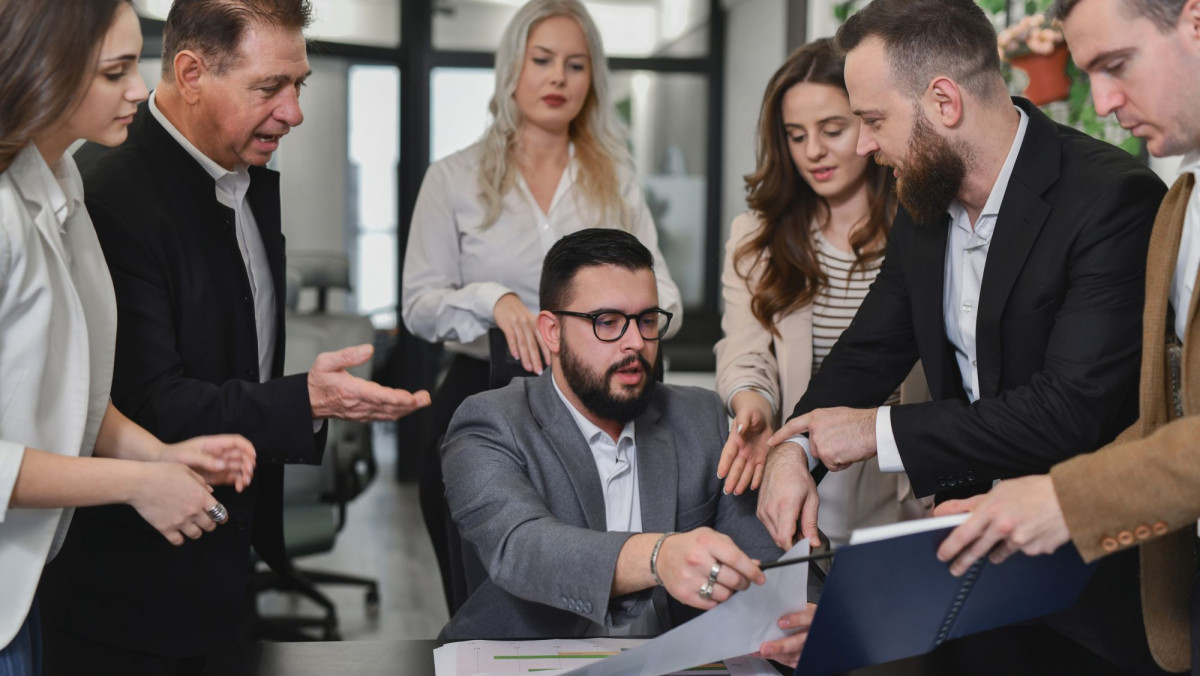 Chef umringt von Mitarbeitenden