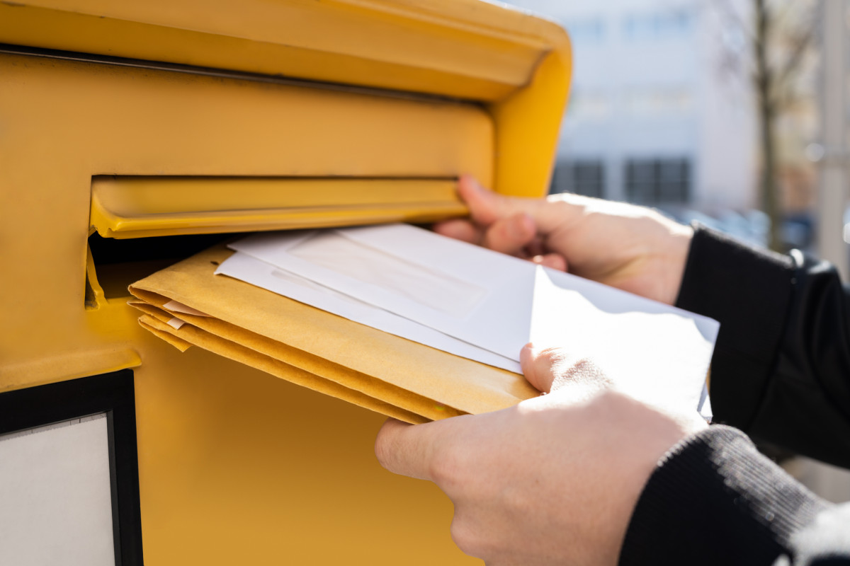 Briefe werden in einen Briefkasten der deutschen Post eingeworfen