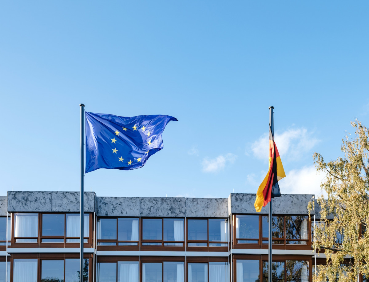 Blaue Flagge der Europäischen Union und deutsche Flagge vor Bundesverfassungsgericht