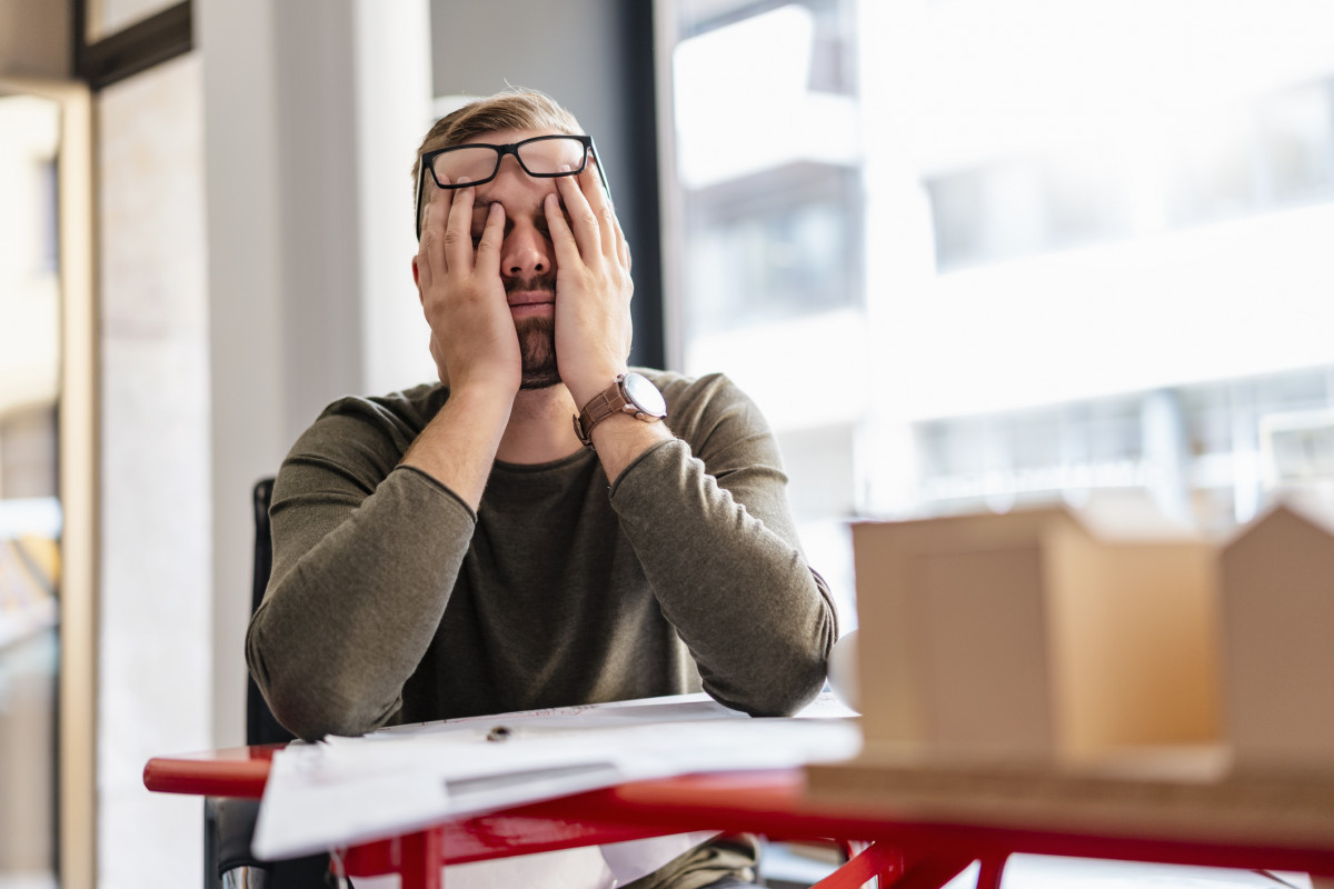 Erschöpfter Mann am Arbeitsplatz.