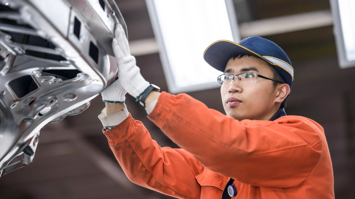 Arbeiter überprüft eine Autokarosserie