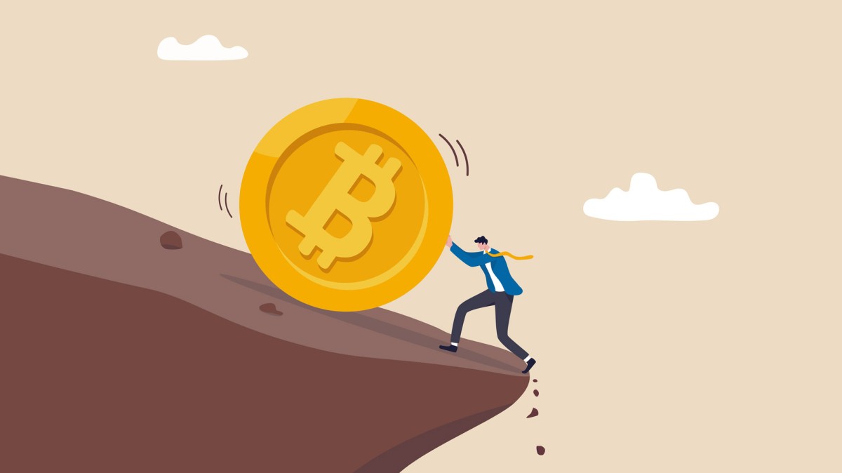 Mensch schiebt einen Bitcoin den Berg hoch