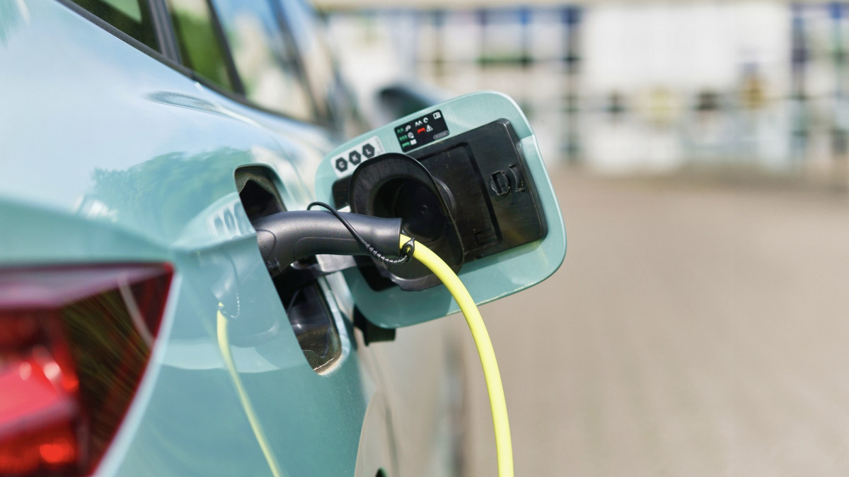 Elektroauto auf dem Parkplatz, angeschlossen an eine Ladestation