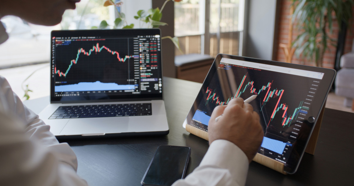 Mann, der auf dem Computer seine Investition an der Börse überprüft
