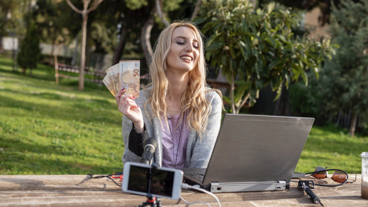Weibliche blonde Bloggerin zeigt verdientes Geld