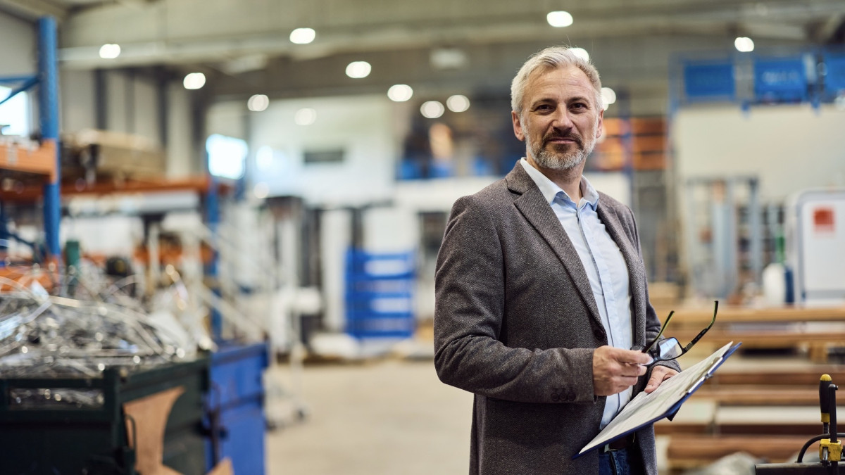 Geschäftsführer im Lager mit Klemmbrett und Brille