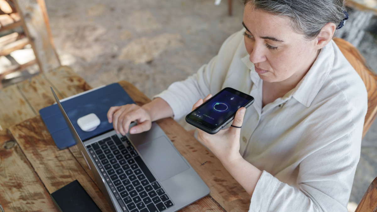 Remote-Mitarbeiter mit KI-Sprachassistent und Laptop