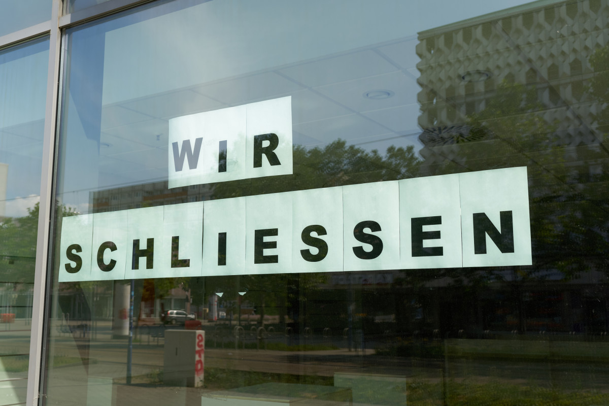 An einem Schaufenster steht "Wir schliessen"