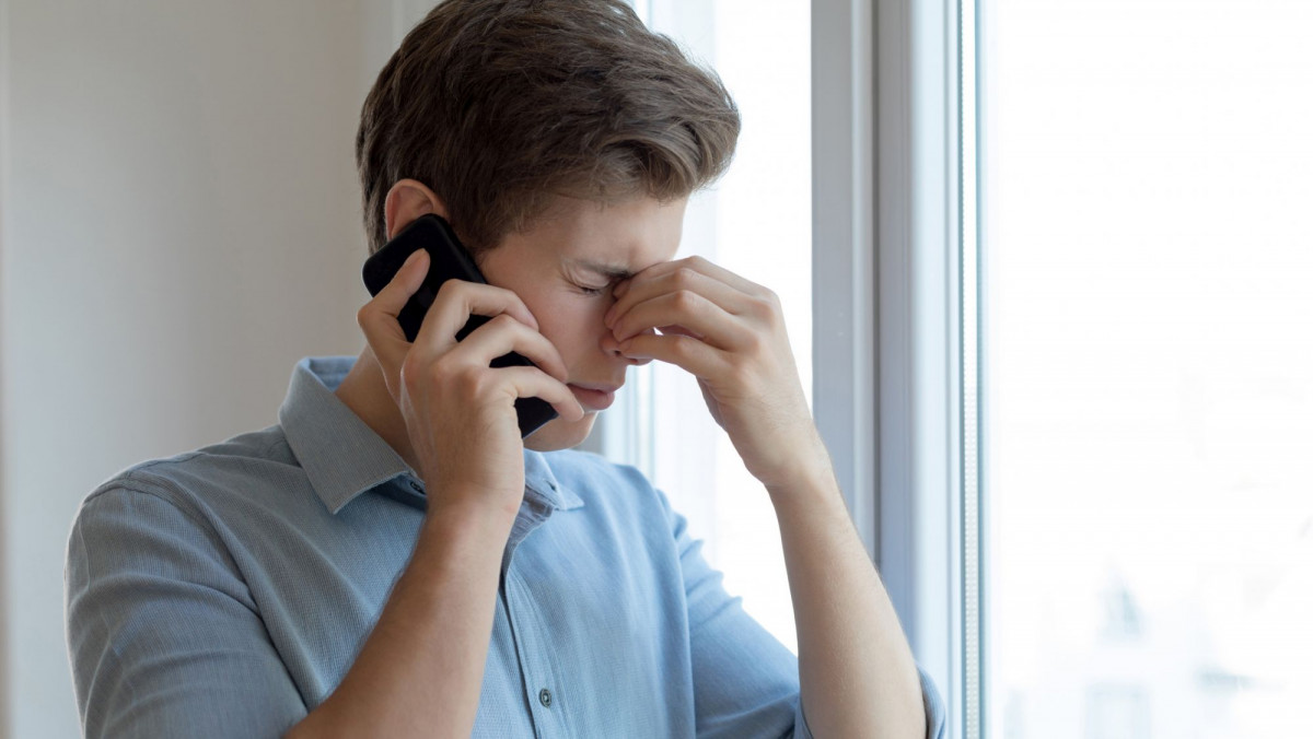 Mann ist genervt vom Telefon-Service