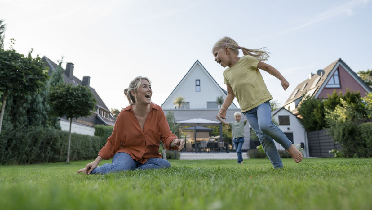 Familie im Garten ihres Eigenheims