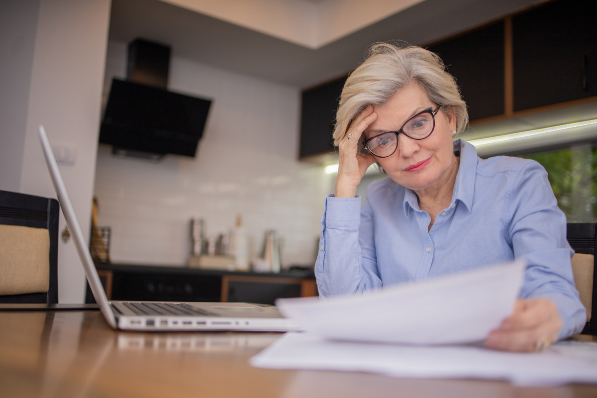 Ein ältere Frau überprüft ihre Finanzen.