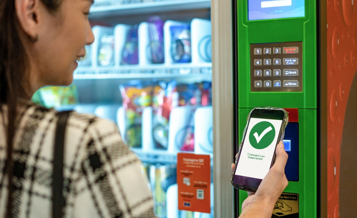 Frau kauft an modernem Snackautomat ein