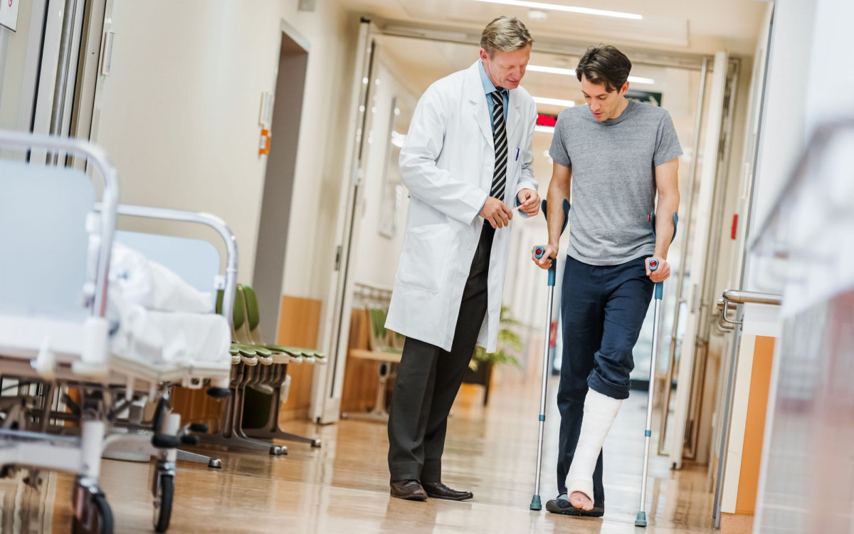 Ein Mann mit Gipsbein und Krücken im Krankenhaus