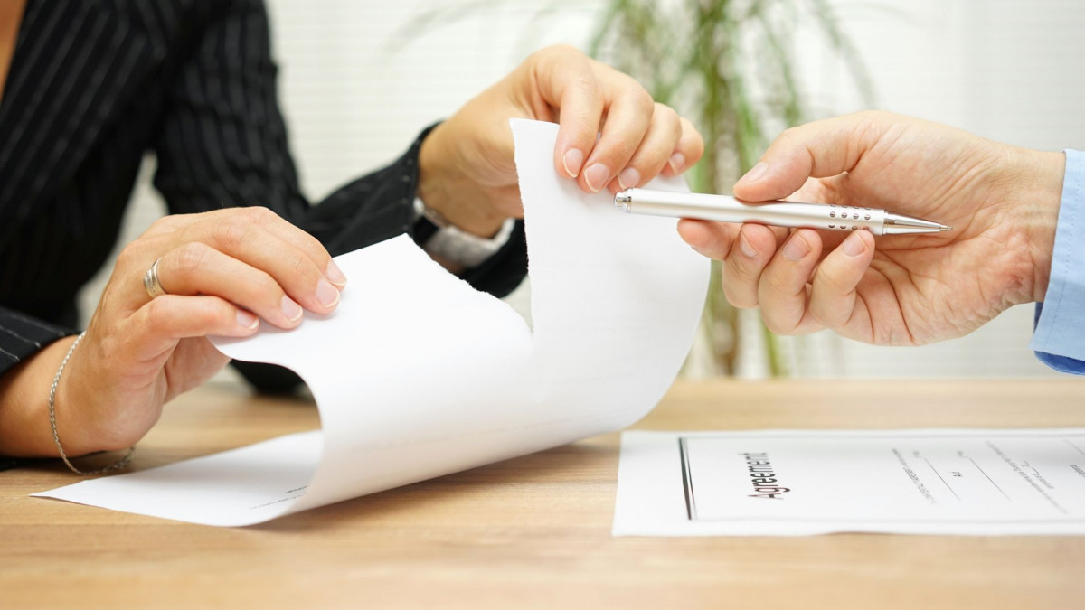 Hände zerreißen ein Blatt Papier