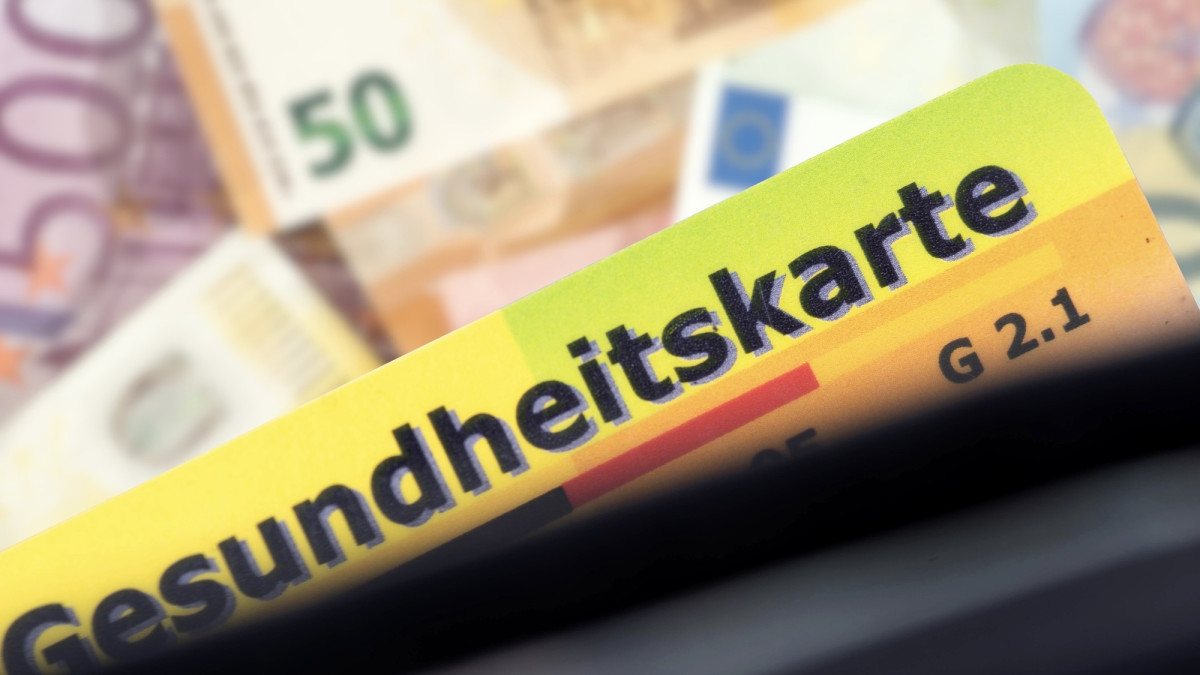 Versichertenkarte einer Krankenkasse und Euro Geldscheine im Hintergrund