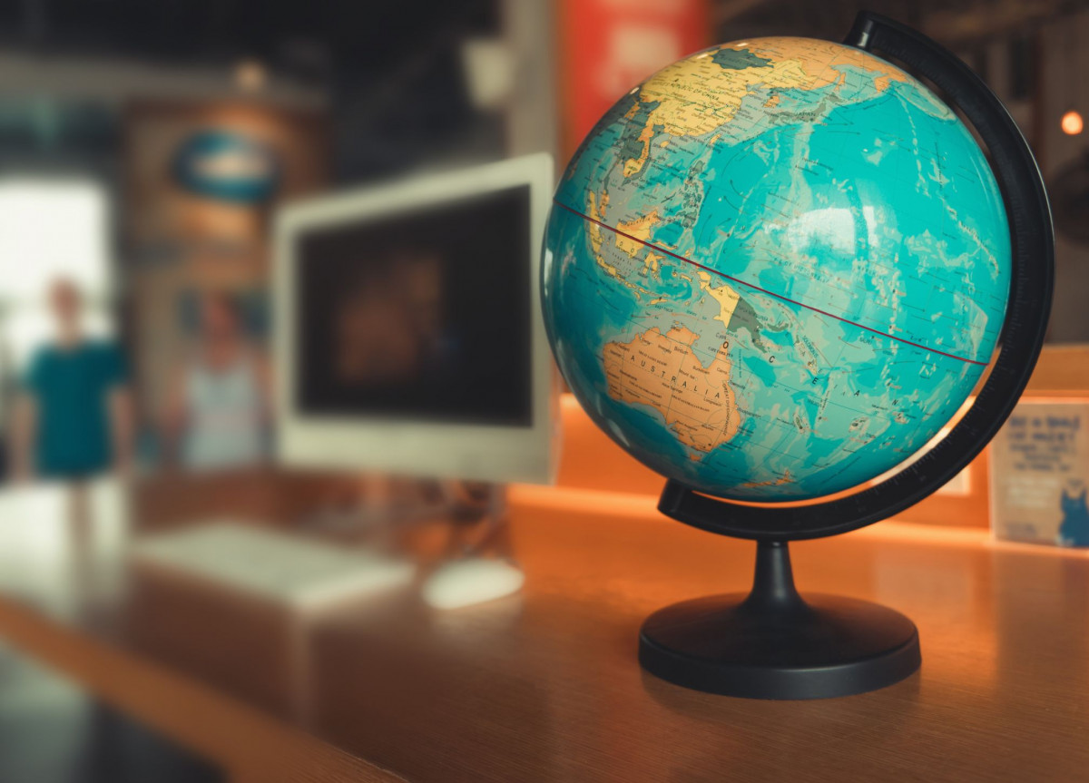 Ein Globus steht neben einem Computer auf einem Tisch