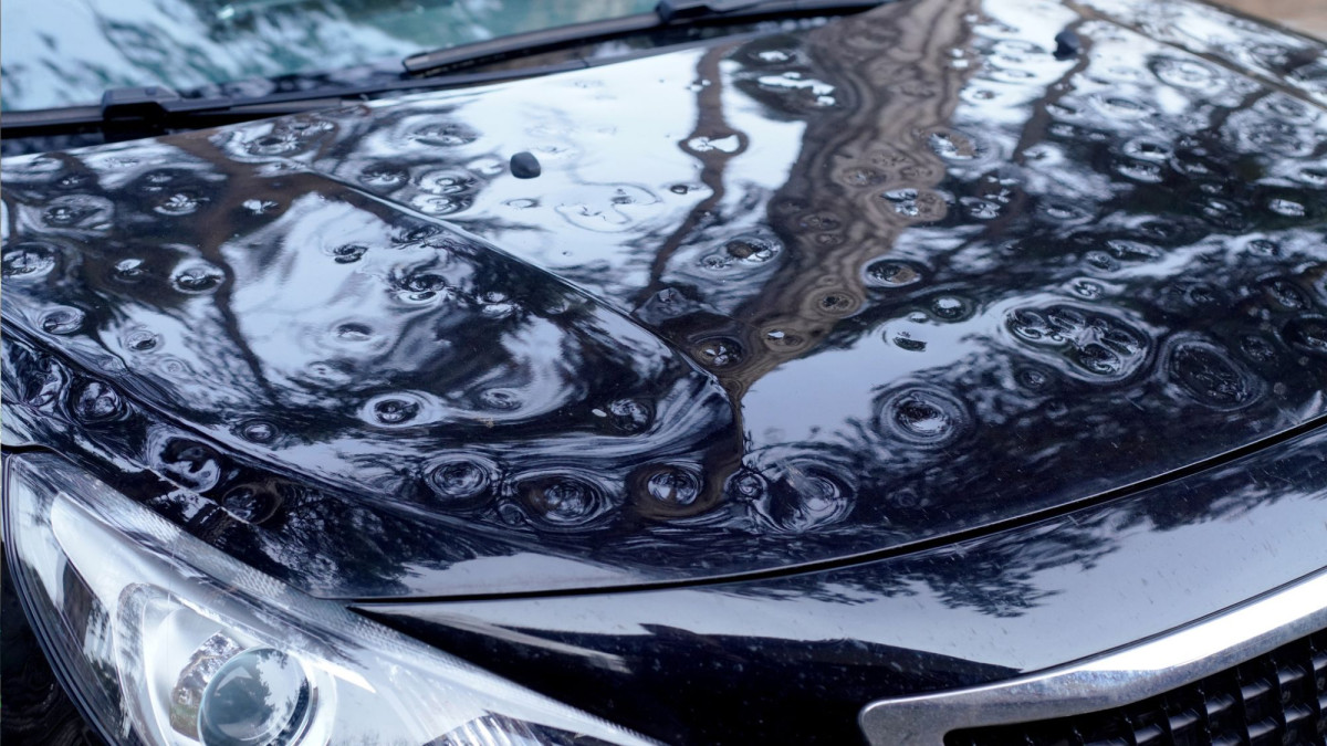 Eine Motorhaube mit sichtbaren Hagelschäden.