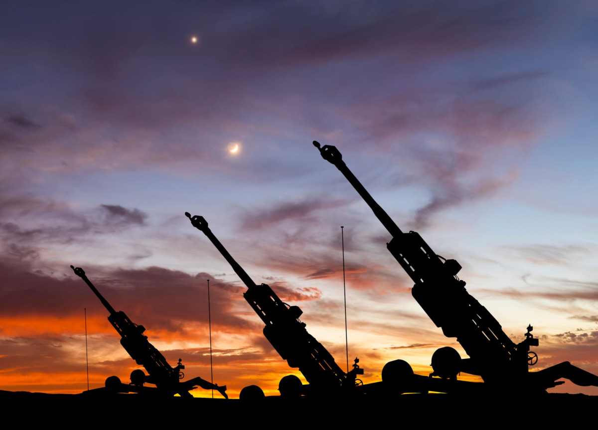 Drei Haubitzen sind vor einem Sonnenuntergang zu sehen