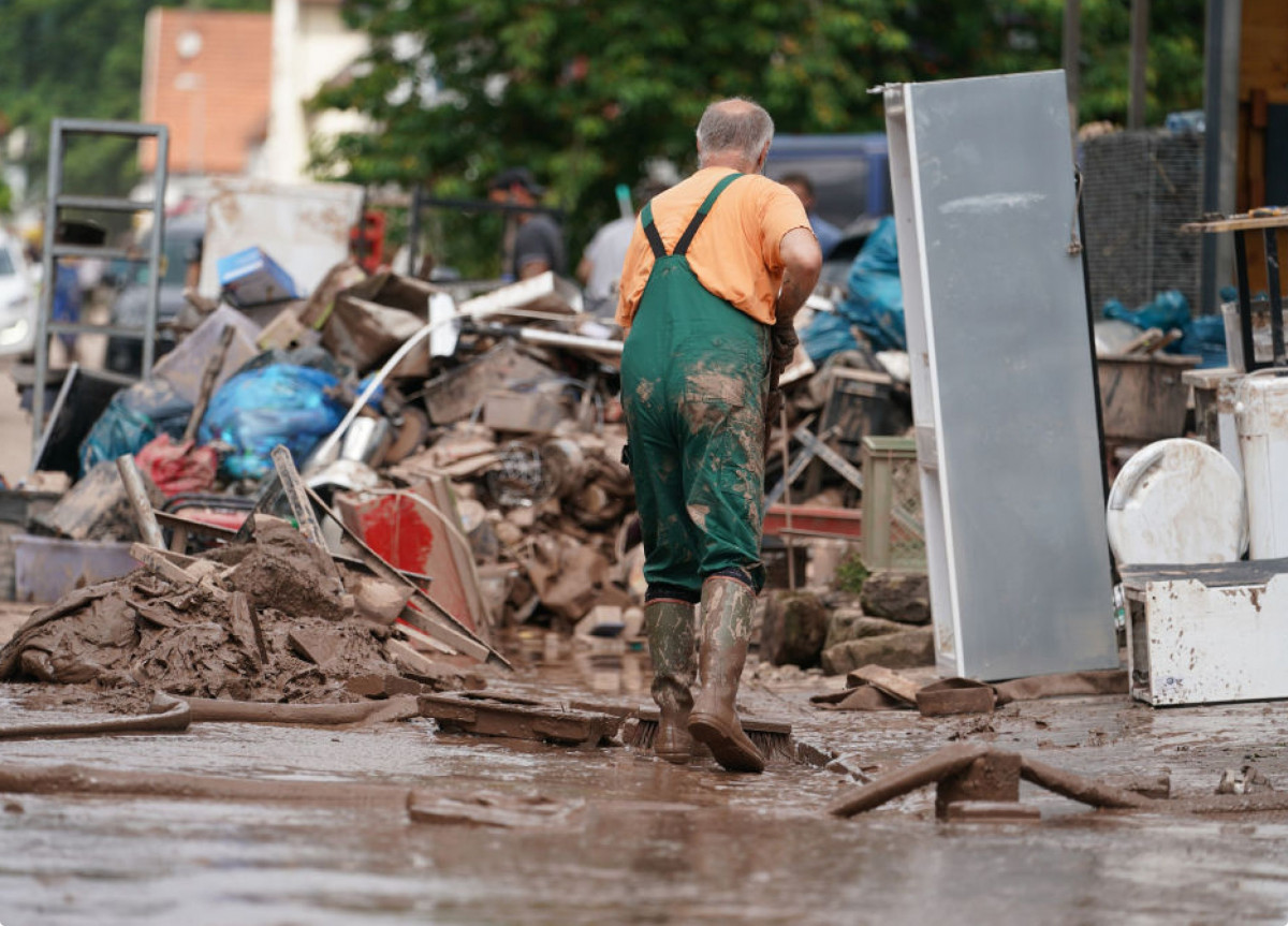 Ein Mann räumt nach einem Hochwasser auf