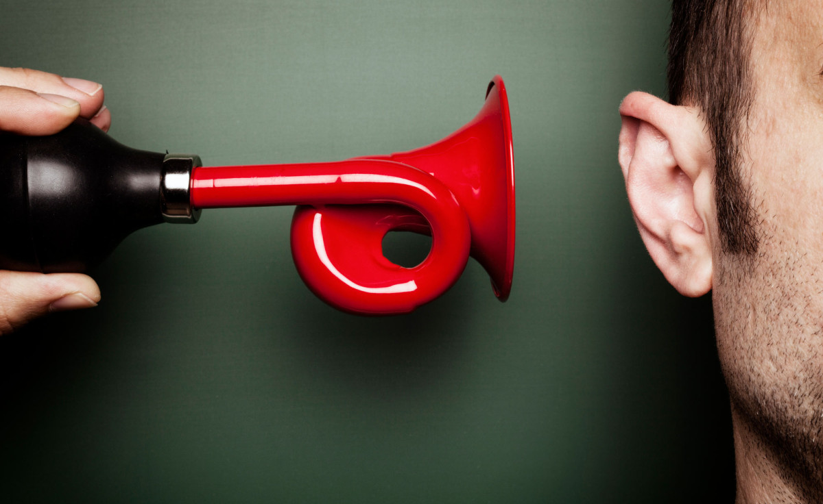 Hupe wird an Ohr gehalten