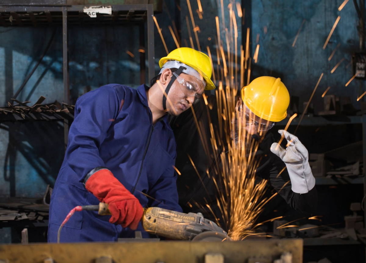 Zwei Arbeiter flexen, so dass Funken sprühen