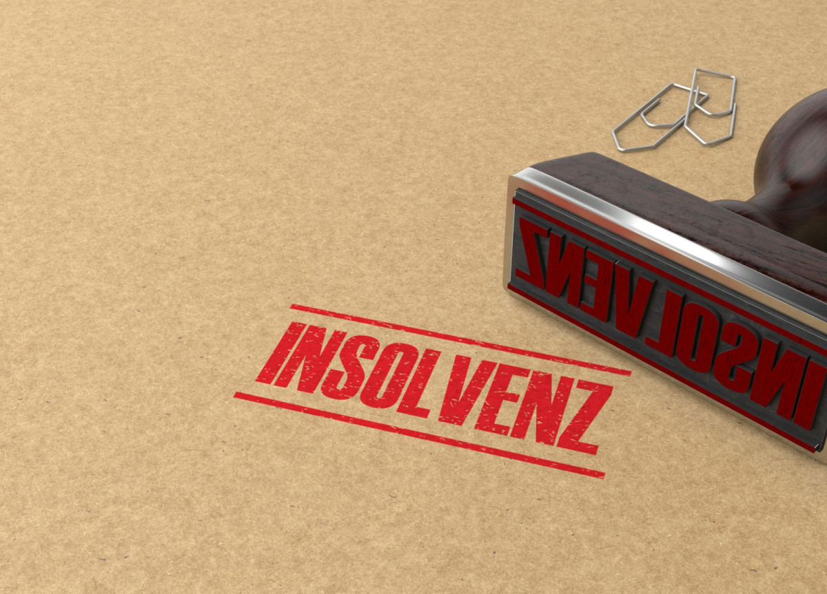 Ein Stempel mit der Aufschrift Insolvenz liegt auf einem Blatt Papier