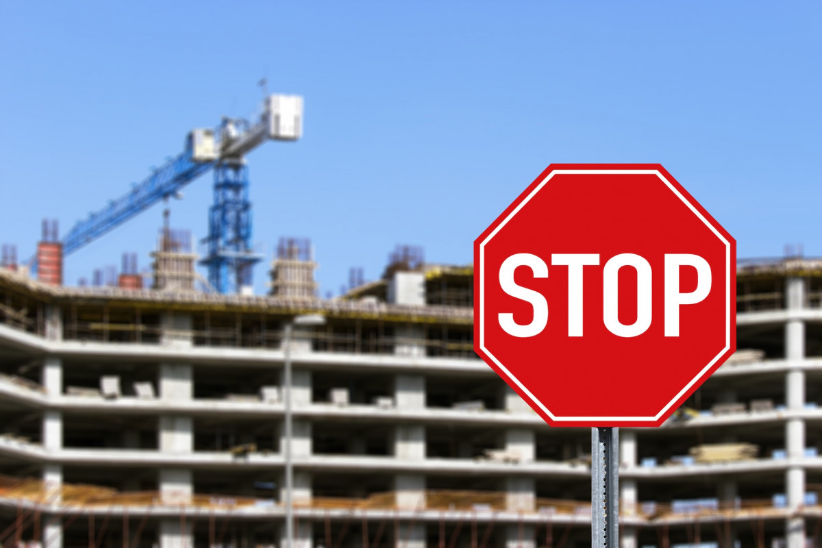 Ein Stop-Schild vor einem großen Gebäude, das sich im Bau befindet