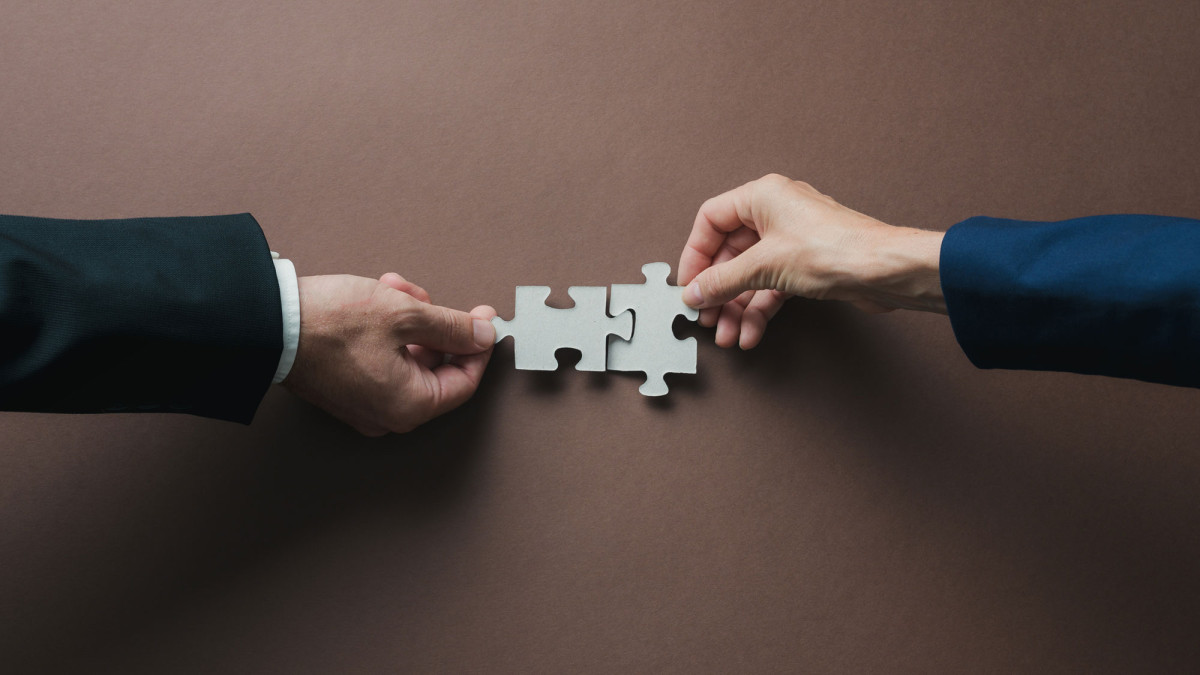 Hände legen Puzzleteile