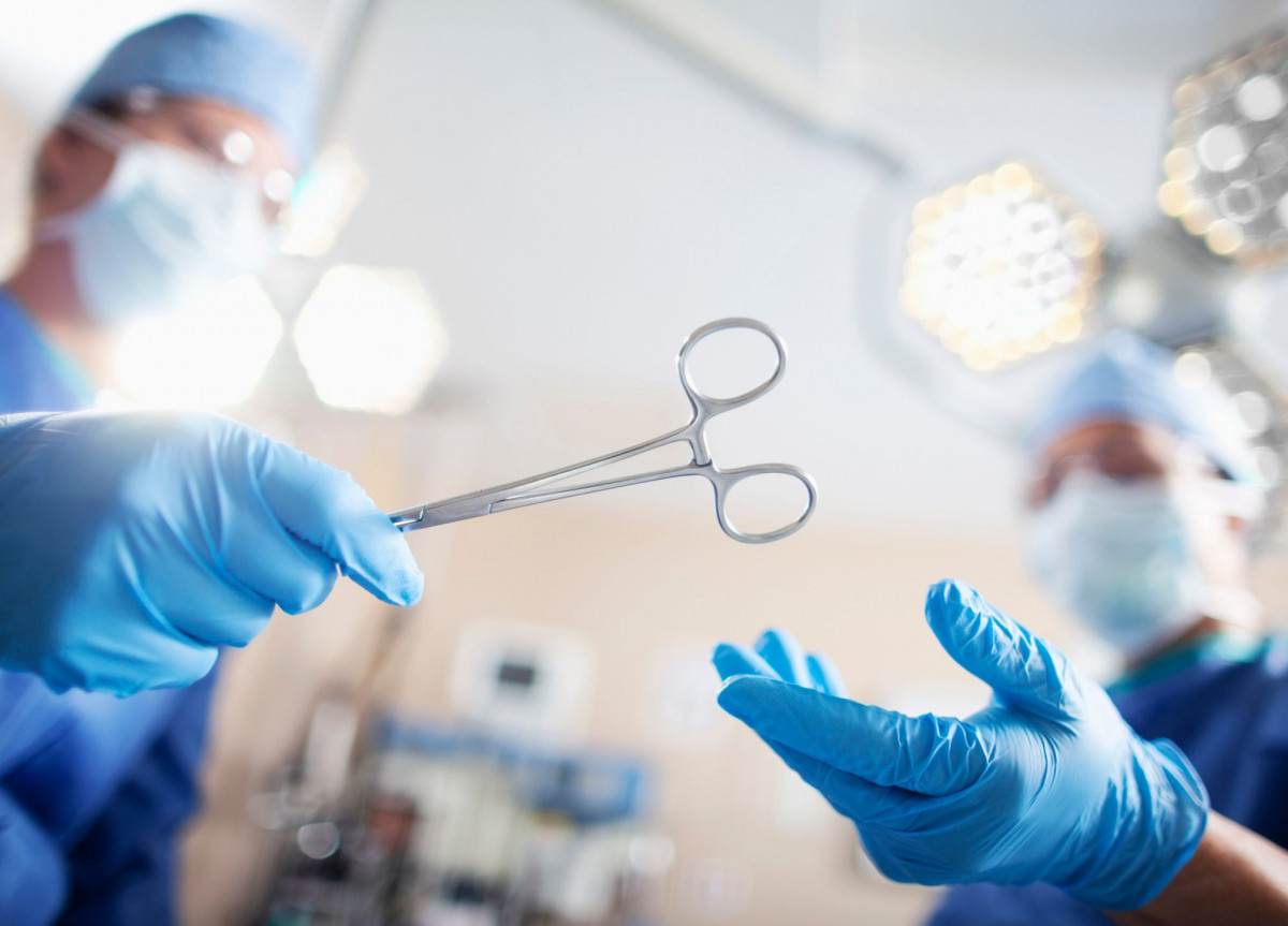 Während einer Operation überreicht ein Arzt einem anderen eine Schere