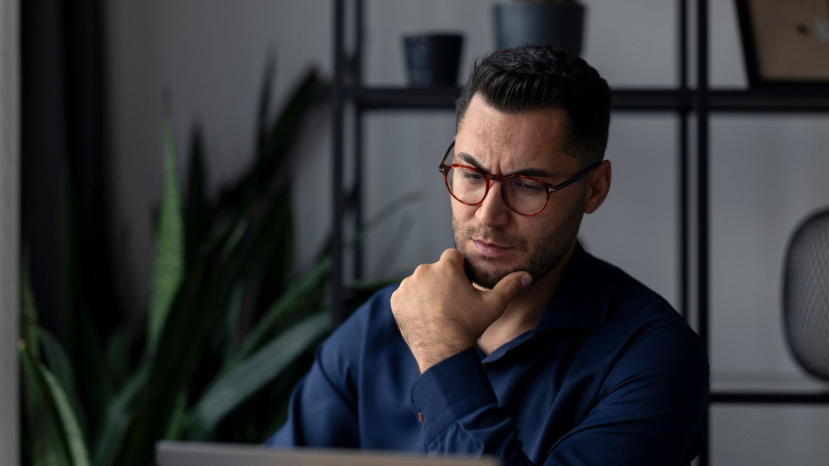 Mann nachdenklich vor Laptop