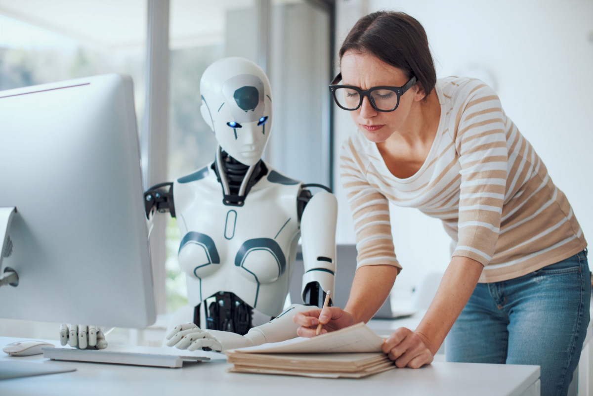 Eine Frau und eine Roboter-Frau arbeiten gemeinsam am Arbeitsplatz.