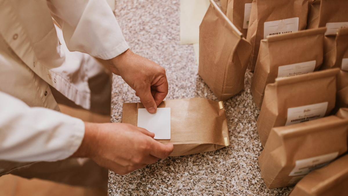 Neue Etiketten werden auf Tüten geklebt