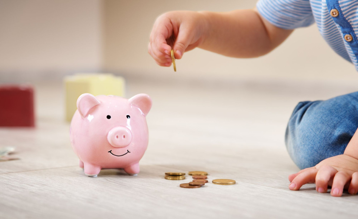 Kind steckt Geld in Sparschwein