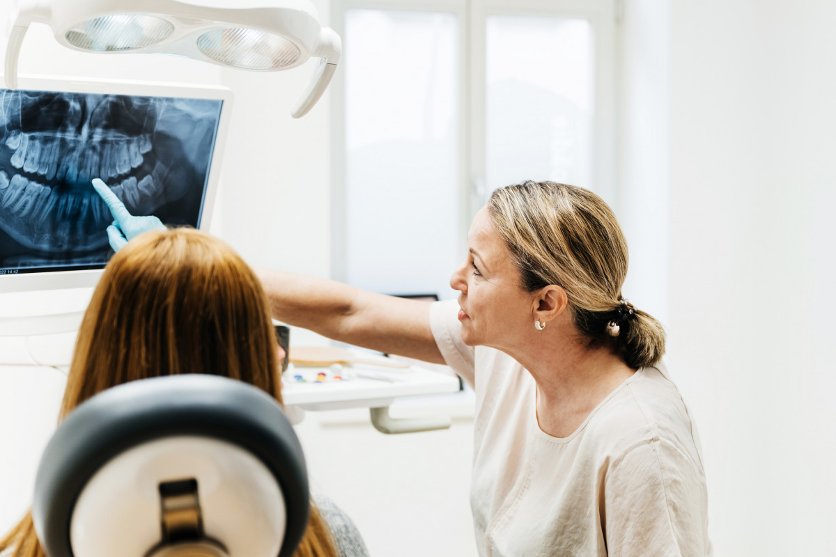 Eine Patientin bespricht mit einer Zahnärztin ein Röntgenbild.