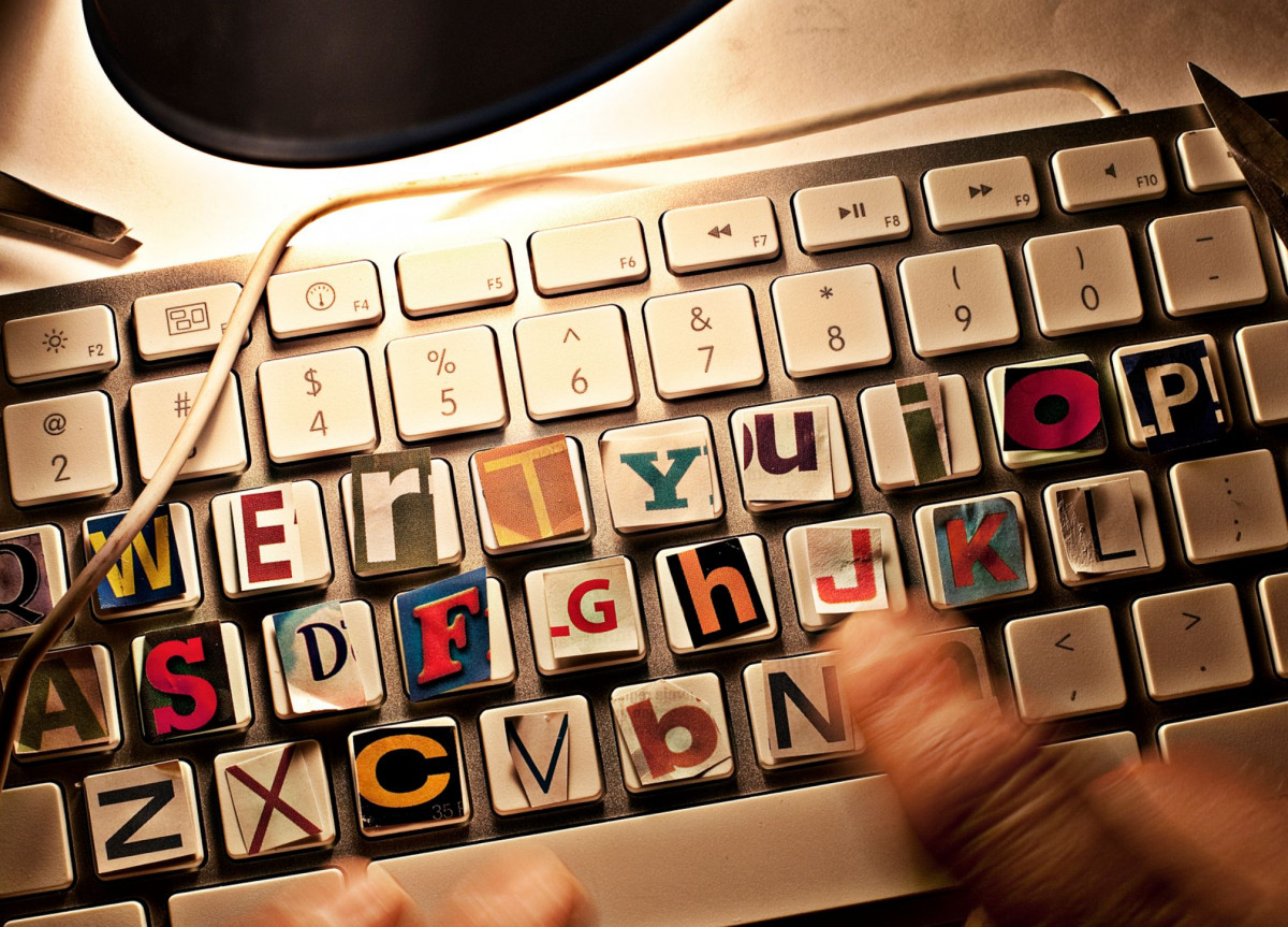 Eine Computer-Tastatur, auf die einzelne Buchstaben aus Zeitungen geklebt sind