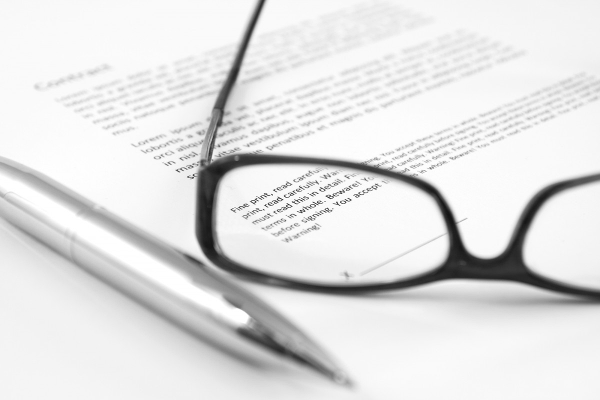 Win bedrucktes Papier auf dem eine Brille liegt