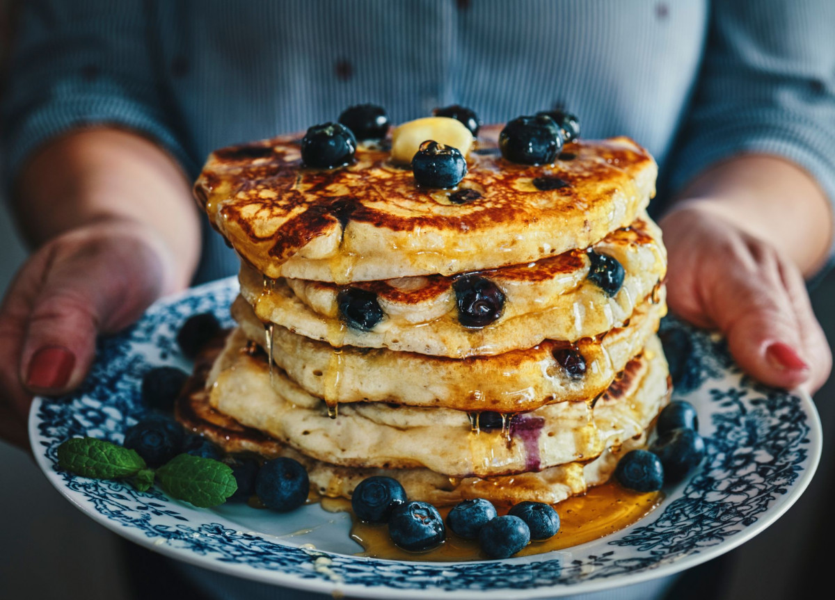 Ein großer Haufen Pfannkuchen mit Blaubeeren auf einem Teller