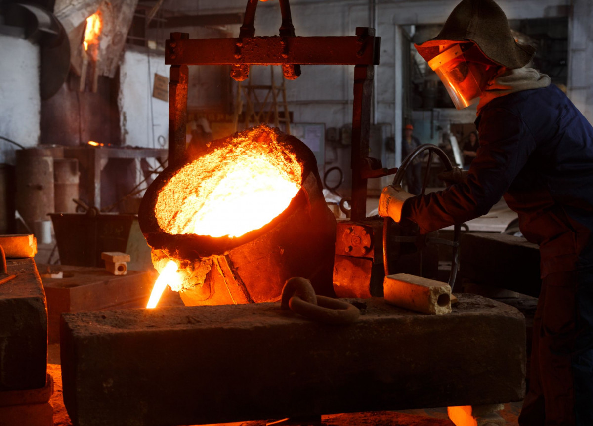 Ein Mann hantiert an einem Schmelzofen