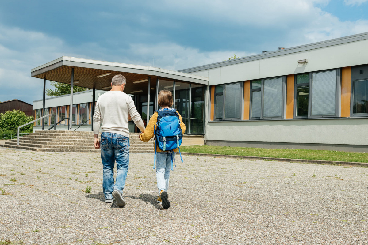 Ein Vater bringt sein Kind zur Schule.