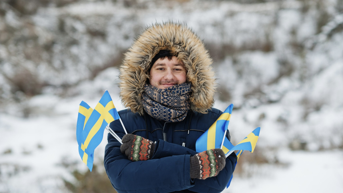 Mann mit Schwedenflagge im Winter
