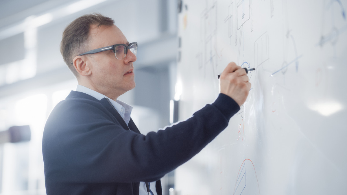 Dozent zeichnet Diagramme auf einem Whiteboard
