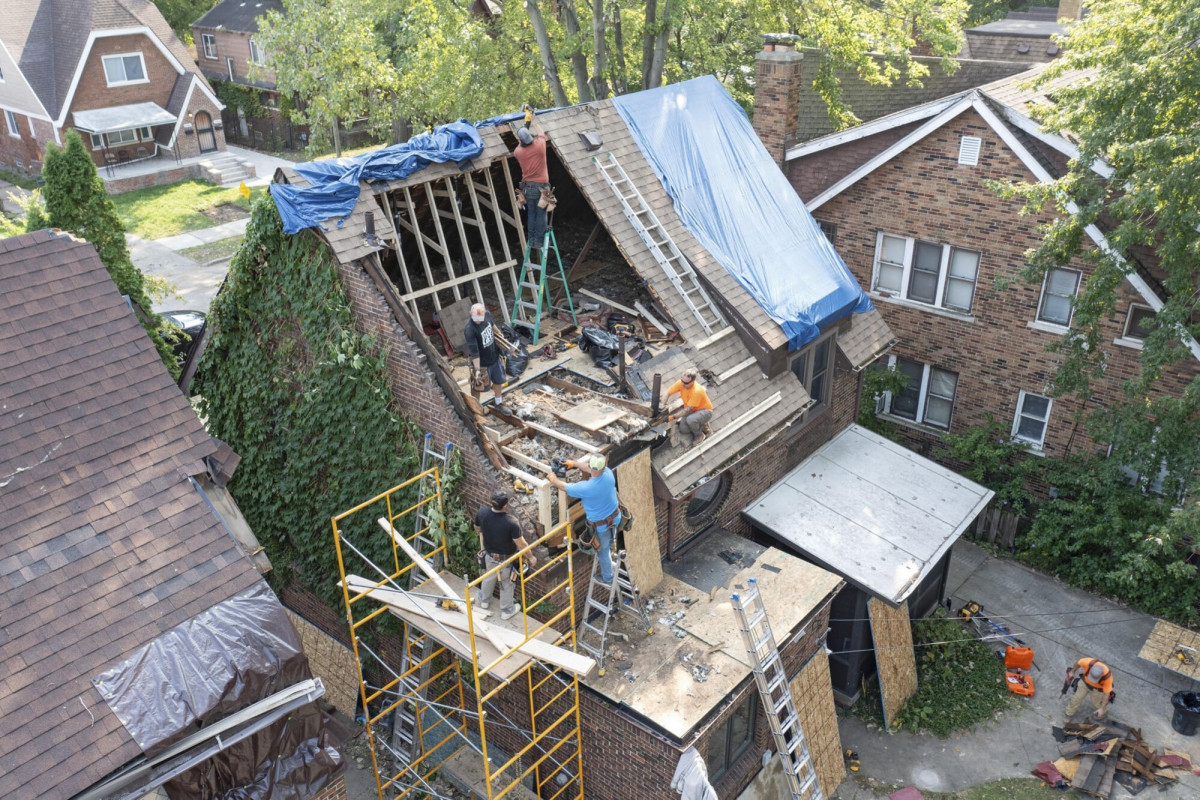 rbeiter bauen den Dachboden eines Hauses wieder auf, der durch einen Sturm zerstört wurde